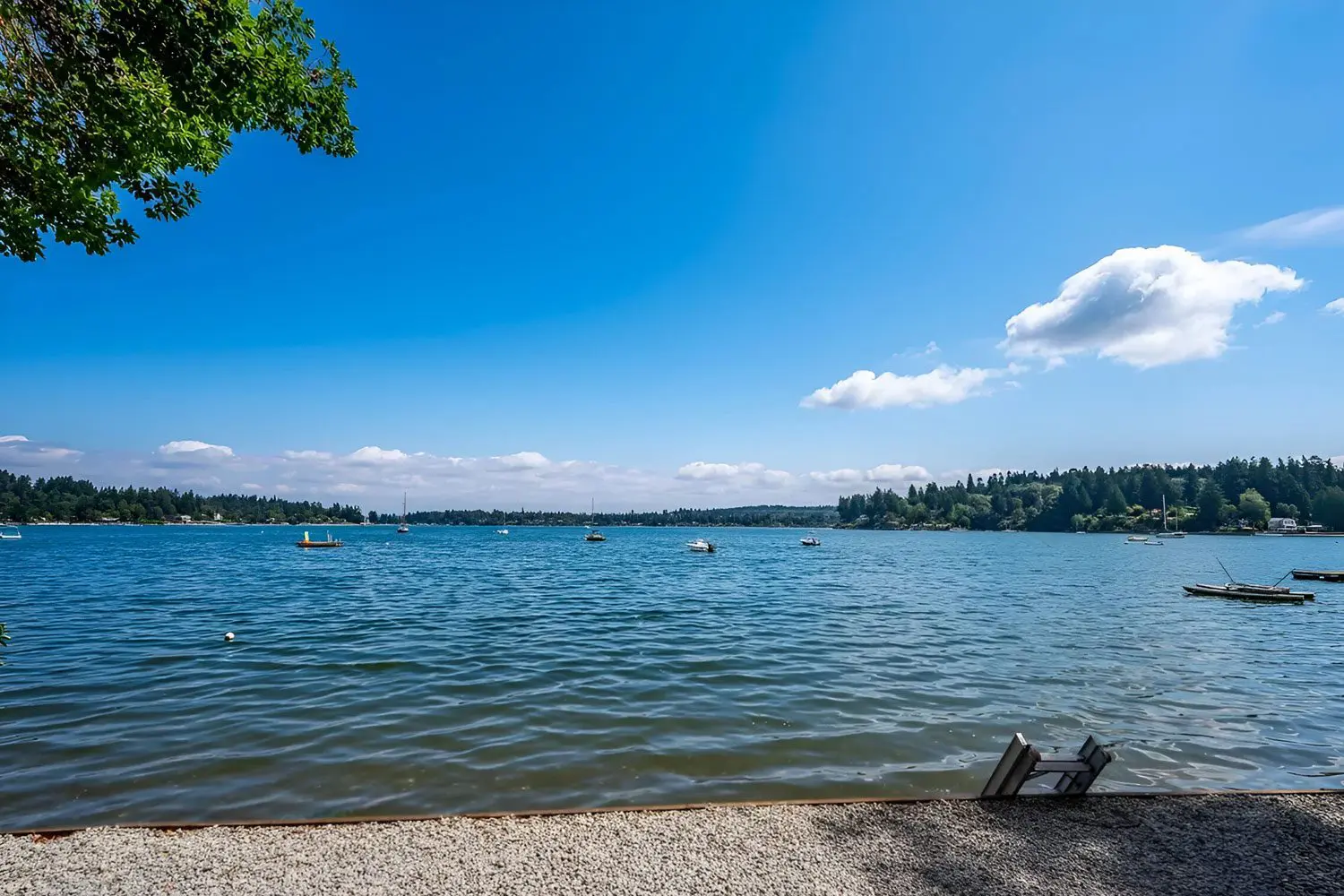 Two people sitting on the beach near a body of water