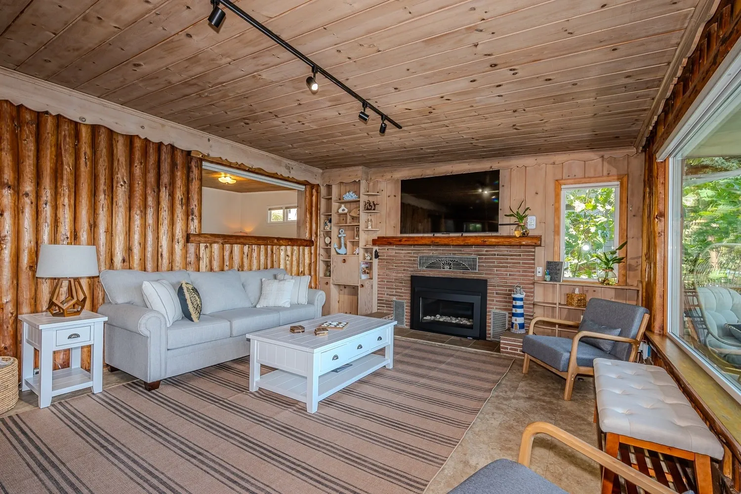 A living room with a couch, chair and fireplace.