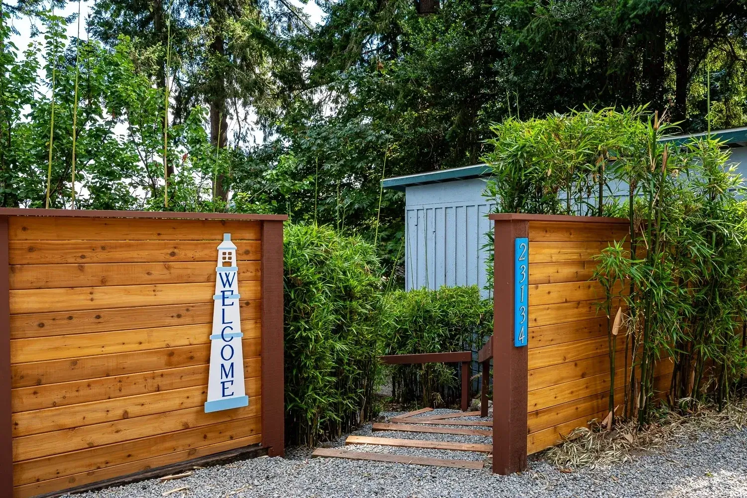 A wooden fence with a blue welcome sign on it.