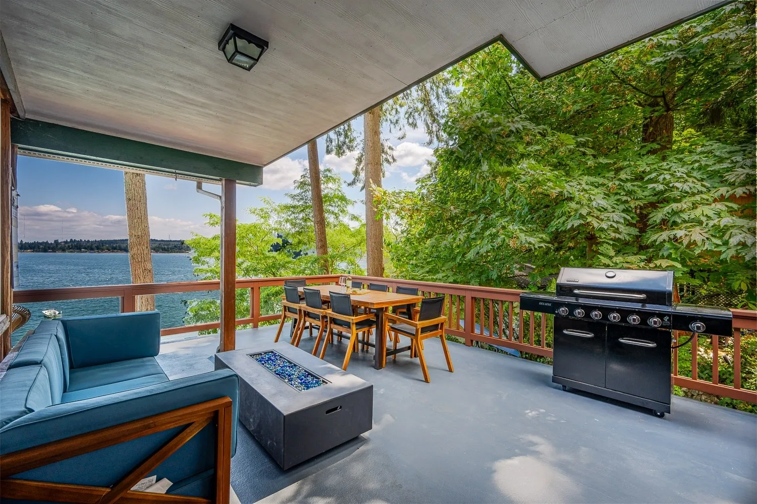 A patio with a grill and table in the middle of it.