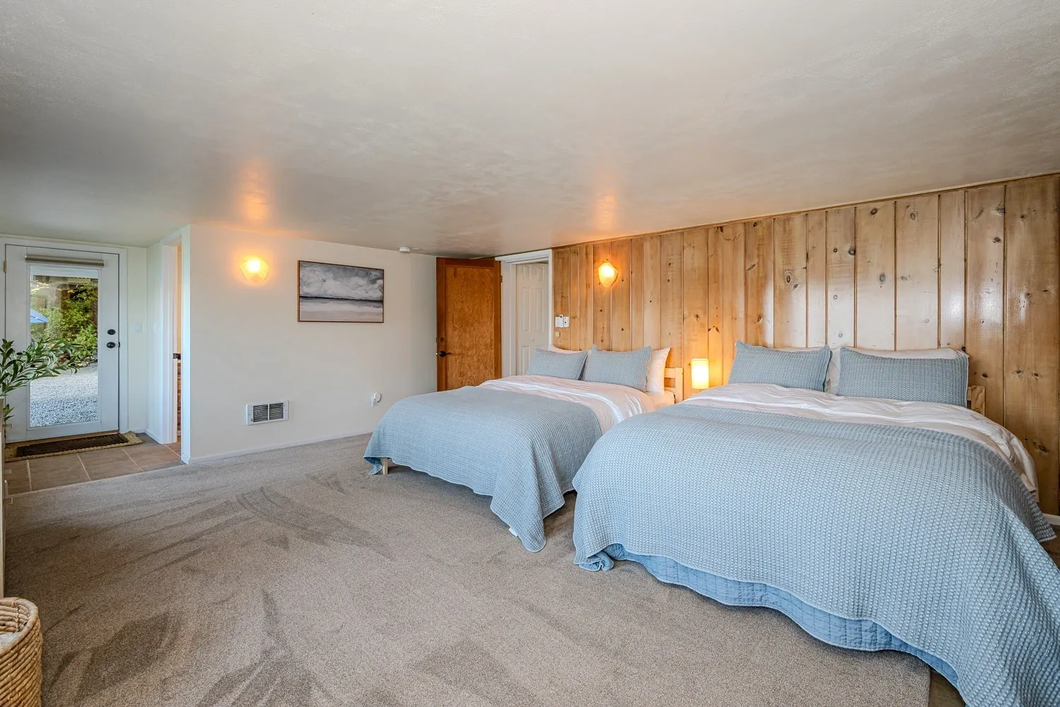 A bedroom with two beds and a large window.